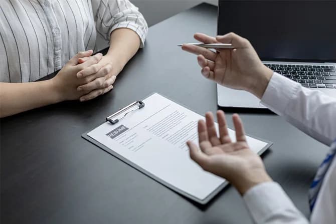 An employer and a new hire reviewing an employment offer